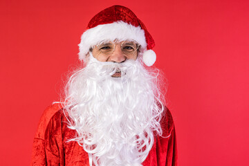 Portrait of a man dressed as Santa Claus, on red background. Christmas, celebration, gifts, consumerism and happiness concept.