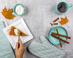 Putting whipped cream on a slice of pumpkin pie.