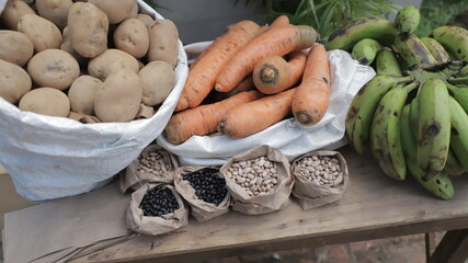 Puesto de comida cruda como zanahoria, papas y platanos verdes. mercado en el exterior