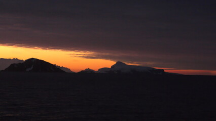 Sunset silhouetting mountains at Cierva Cove, Antarctica
