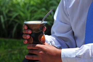 Man holding yerba mate in nature. Travel and adventure concept. Latin American drink yerba mate.
