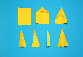 Making paper plane step by step. Instruction on light blue background, flat lay