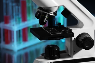 Closeup view of modern microscope with glass slide in laboratory, toned in blue. Space for text