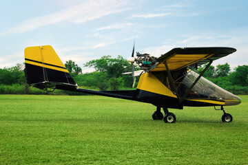 Modern light aircraft on green grass outdoors