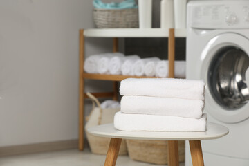 Folded soft terry towels on white table in bathroom, space for text