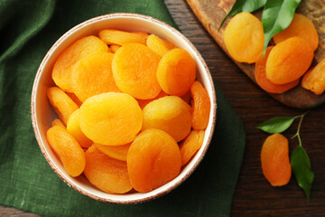 Bowl of tasty apricots on wooden table, flat lay. Dried fruits