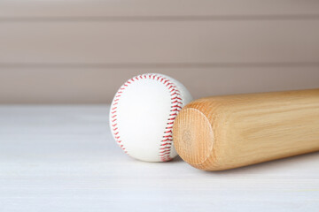 Baseball bat and ball on white wooden table, space for text. Sports equipment