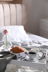 Romantic breakfast with note saying I Love You on bed