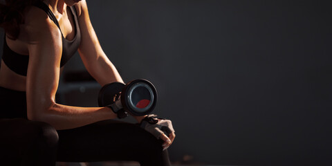 Sporty woman holding weight dumbbell doing fitness workout in the gym.