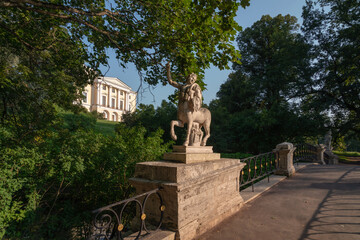 Centaur Bridge in Pavlovsky Park against the background of the Pavlovsky Palace on a sunny summer day, garden and park reserve in St. Petersburg, Russia