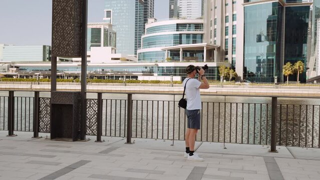Man Capturing Photos Of Tall Buildings And Skyscrapers Across The River