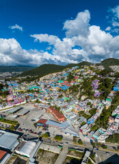 Aerial view of colorful mountain village of San Cristobal de Las Casas in Mexico. Clouds over the mountains. Panorama.