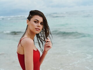 Portrait of a beauty woman on the beach with beautiful tanned skin and wet hair against the ocean summer vacation