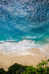 Beautiful ocean waves and white beach with people from top of the clift.