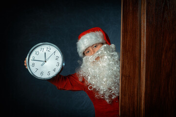 portrait of a boy in a santa costume with a clock - 549879903