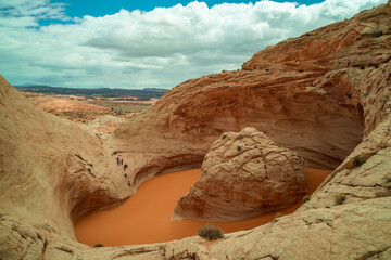 Hikers visit a unique sandstone geological feature known as the 'Cosmic Ashtray' located in Grand Staircase-Escalante National Monument in southern Utah. Several people attempt to descend into the pit