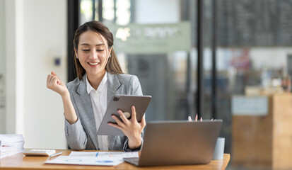 Happy excited successful business asian woman triumphing in office