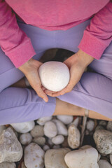Female hands holding white natural stone formation yoga harmony spa treatment relaxation healthcare
