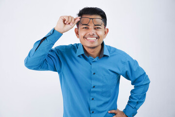 smiling or happy handsome asian businessman lifting glasses to forehead with hand looking camera and wearing blue shirt isolated on white background
