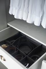Male wardrobe closet open dresser drawer leather belt storage organizing accessories neatly folded