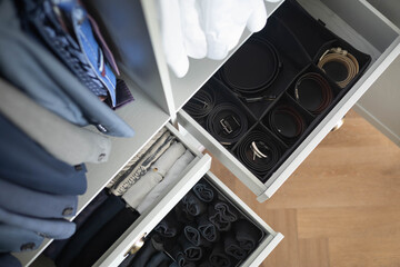 Man cupboard clothes storage organization neatly folded belt underwear shirt and socks