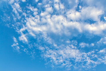 Fototapeta premium Clouds in the blue sky. Natural sky background texture, beautiful color. Peaceful blue sky with light clouds. The free form beauty of clouds and sky is perfect for background, backdrop and wallpaper.