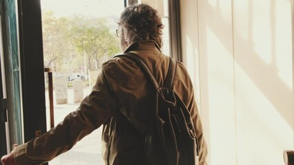 Middle aged man leaving home with luggage