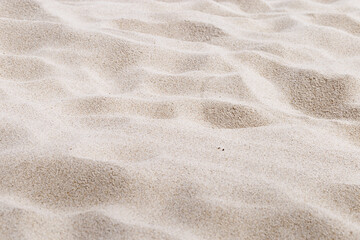 Fototapeta na wymiar Beige Sand texture natural background. Close up sandy beach on shore sea, waves textured dunes, light color, minimal nature fon. Summer and travel, spa and rest concept. Selective focus.