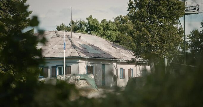 Mountain cottage on peak of mountain Trdinov vrh near a radio tower surrounded with trees. A Slovenian flag lightlly flutters in the breeeze.