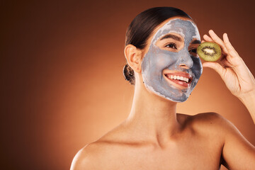 Face, skincare and woman with clay mask and kiwi in studio on a brown background mockup. Organic cosmetics, fruit and happy female from Canada thinking about healthy facial treatment and nutrition.