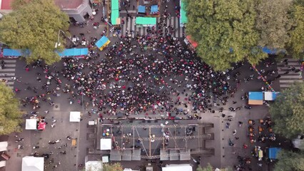 People dancing Chacarera folk popular dance during Feria de Mataderos in Buenos Aires city, Argentina. Aerial top-down ascending directly above