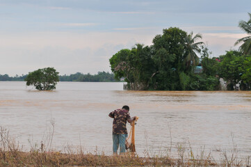 a man was fishing in a flooded rice field