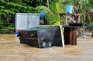  an overturned garbage can washed away by floodwaters