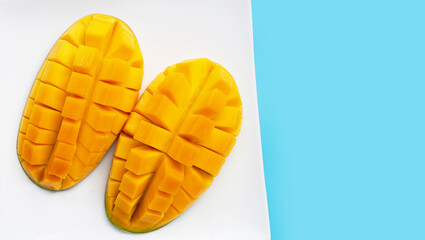 Tropical fruit, Mango in white plate on blue background. Top view
