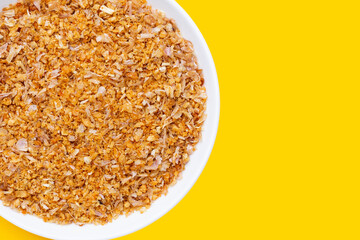 Dried chopped garlic on yellow background.