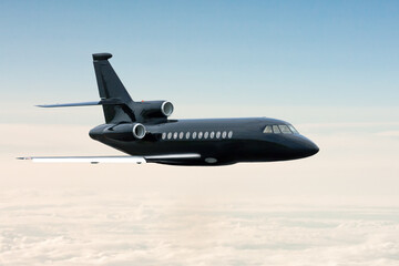 Black modern private jet flying in the air above the clouds