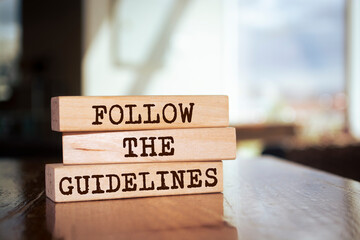 Wooden blocks with words 'Follow The Guidelines'.