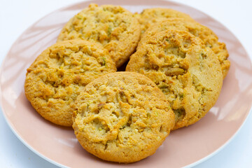 Pistachio and almond cookies on white background.