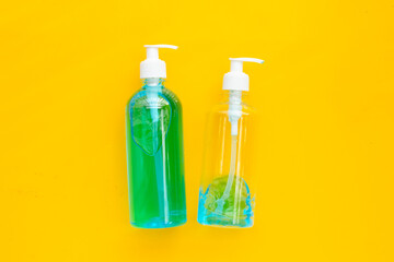 Alcohol liquid gel sanitizer on yellow background.