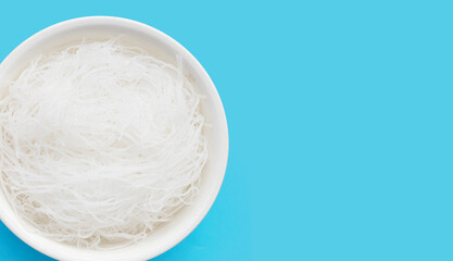 Vermicelli in white bowl on blue background.