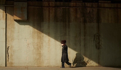 a hasidic jewish man walking down the street under the bridge in williamsburg brooklyn - obrazy, fototapety, plakaty