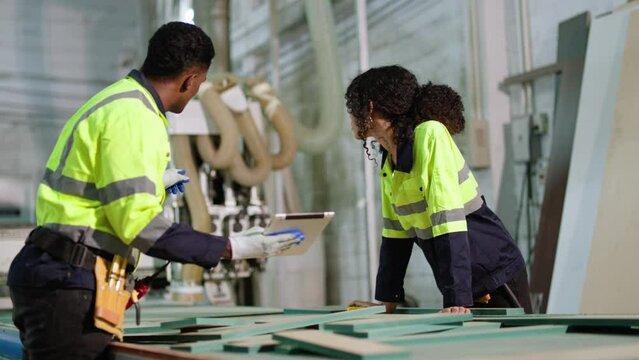 African American worker and his colleagues work in a factory for the production of furniture,the process of treating wood,work woodworking machine.training industry factory worker concept.