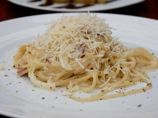 spaghetti with cheese and pepper on a white plate