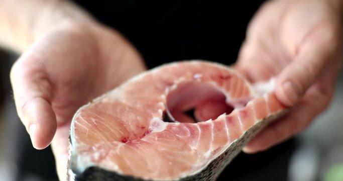Fillet piece of salmon in hands of chef
