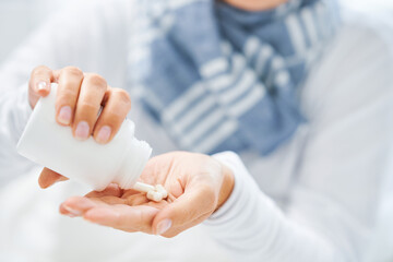 Young brunet woman sick in the bed taking medicine