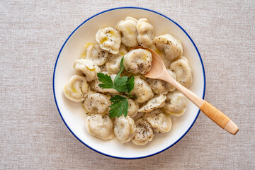 Plate with dumplings on cotton fabric background.