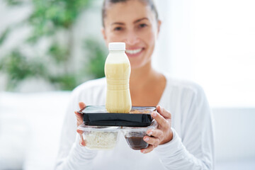 Young woman on bed with food catering box