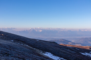 Panoramic view of the Schladminger Tauern mountain range at early morning after sunrise seen from Saualpe, Lavanttal Alps, Carinthia, Austria, Europe. Snowcapped mountain peaks in the Central Alps