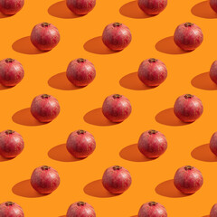 Seamless pattern with fresh pomegranate fruit for Jewish holiday Rosh Hashanah on orange background.