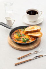 Pan of cooked shakshuka middle eastern dish with bread